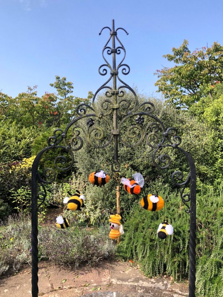 Knitted bees at Upper High Street Gardens