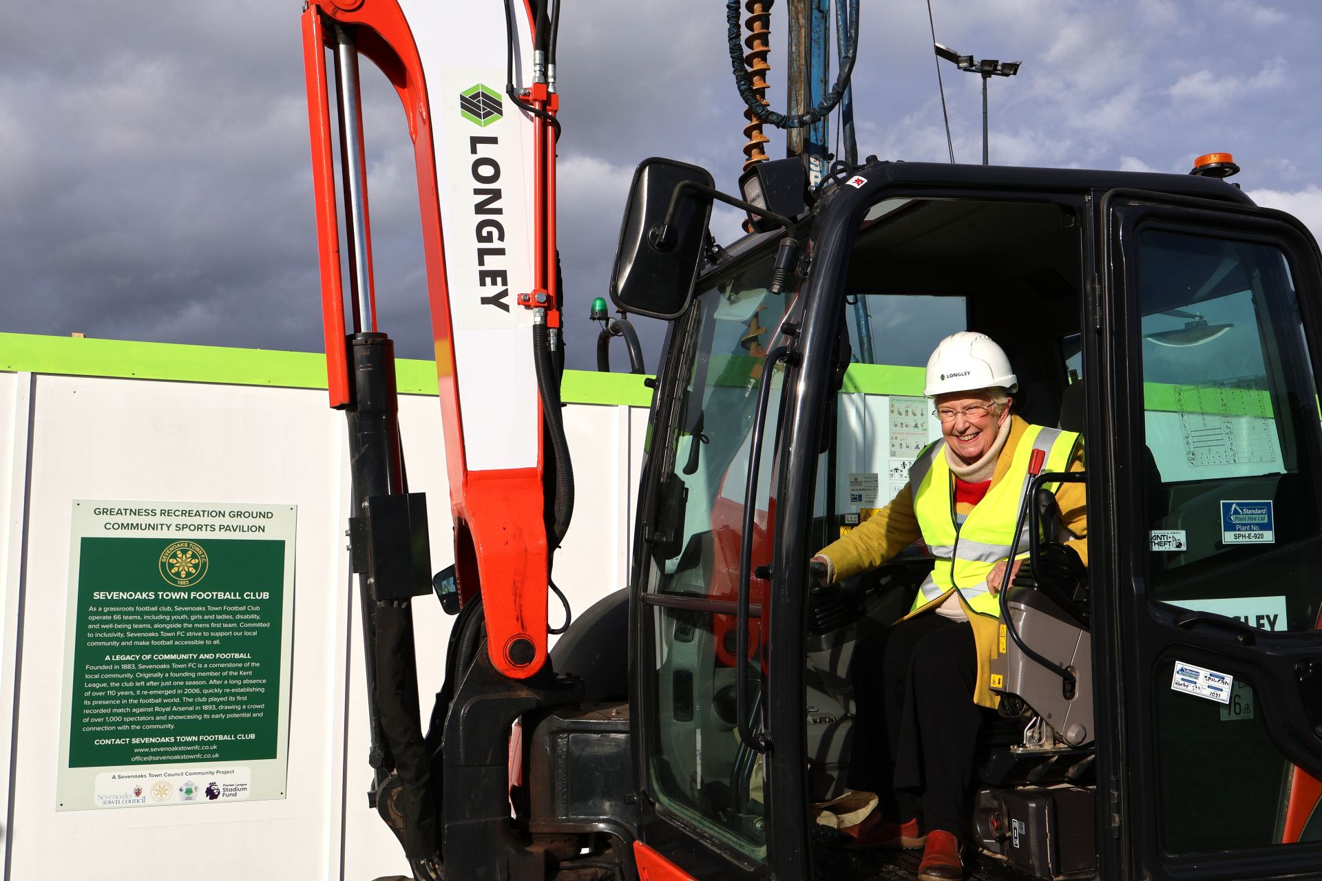 Cllr Canet sits on digger at Greatness Pavilion sod cutting