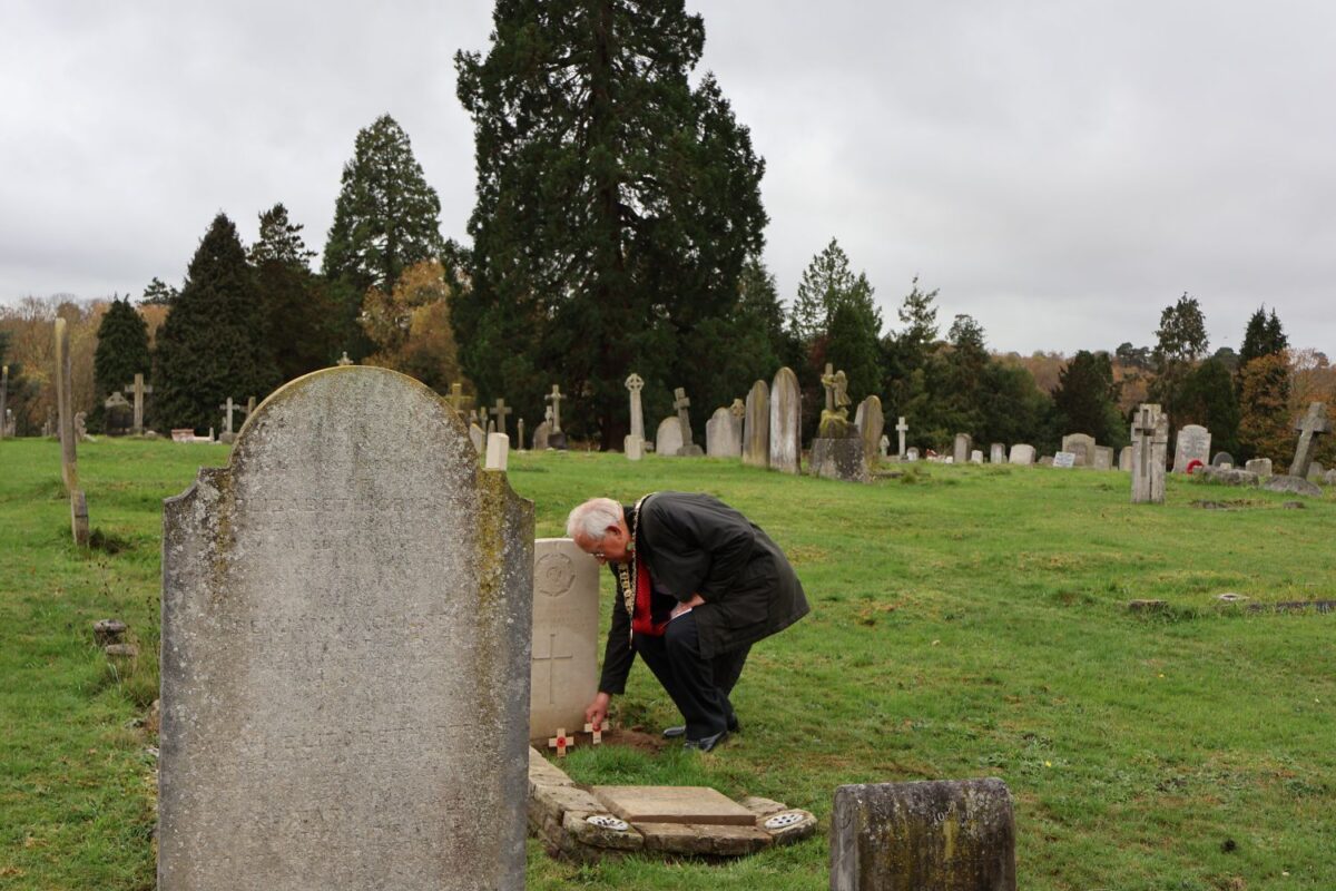 Laying a cross on a grave